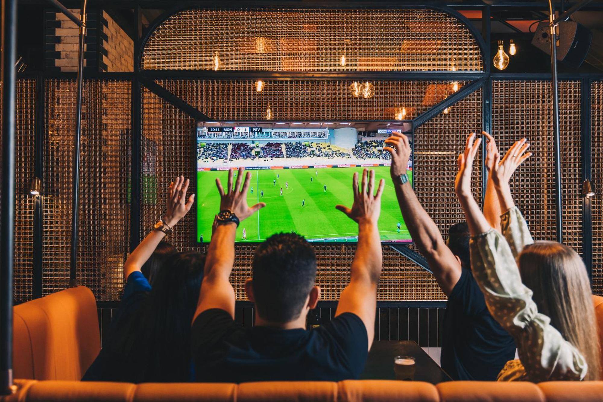Five Jumeirah Village Dubái Exterior foto Watching a game on television